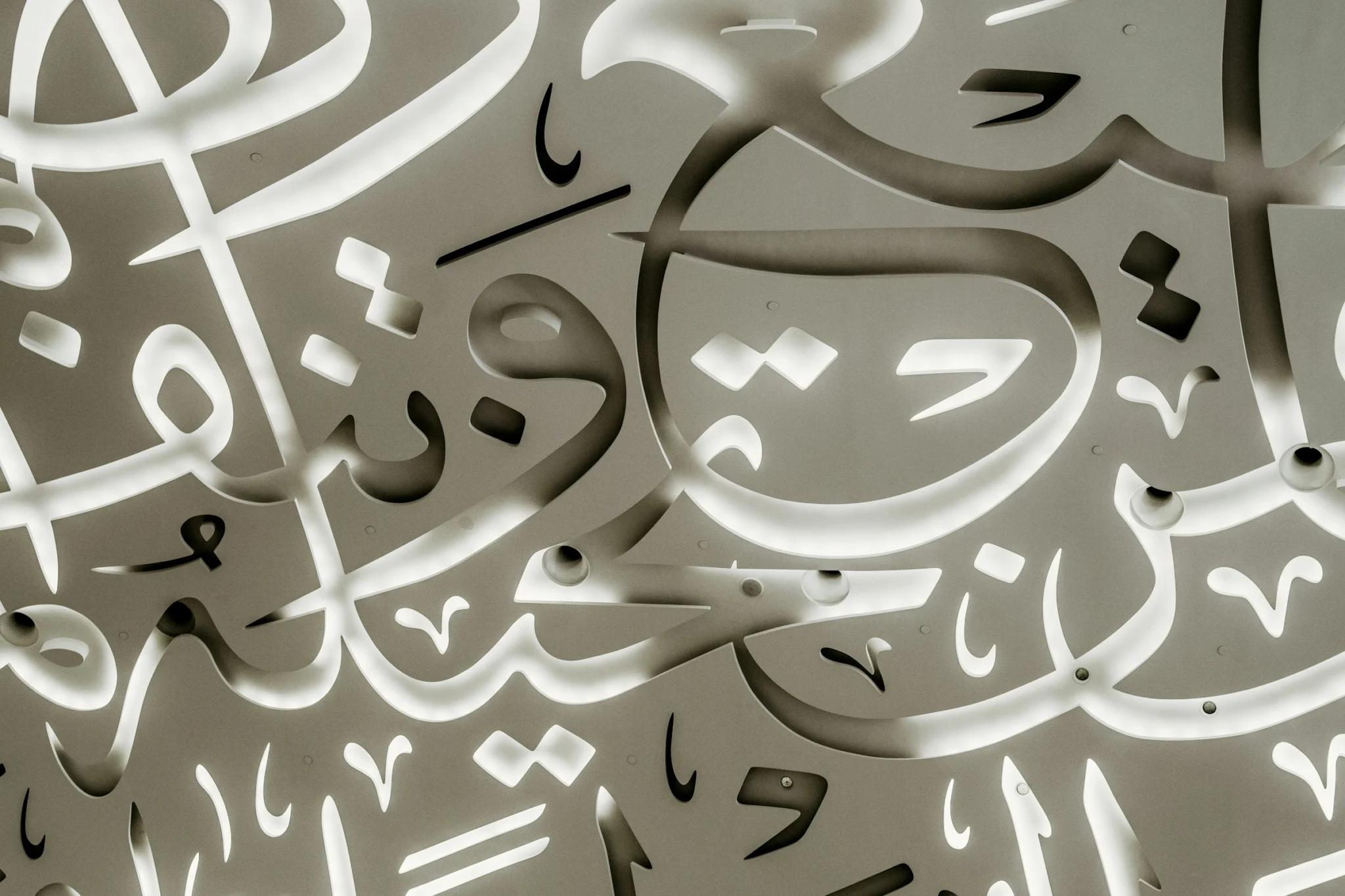 Close-up of Arabic calligraphy cut into a white surface